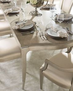 a dining room table set with place settings