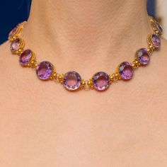 We are pleased to present this impeccable Victorian 15ct Gold Amethyst rivière necklace! This Victorian necklace was made circa 1880, and is bountiful in beauty, complete with 18 round-cut Amethyst gemstones that subtly graduate in size with a total spread of 108.00ct. Each beautifully faceted grape-hued Amethyst has been set into rich 15ct Gold claw settings, each possessing a subtle variation in hue from iris to lilac. This rivière sits at 16", making it the perfect length to adorn your collarbones and on those occasions when you need a final flourish of fancy - let this treasure do all the talking... ERA: Victorian, c.1880. MEASUREMENTS: Necklace is 16" or 40.5cm long. Amethysts graduate from 11.5 to 14.5mm in diameter, weighing approx 108.00ct combined. Weight: 52g. MATERIALS: Tests as Exquisite Amethyst Necklace For Formal Occasions, Exquisite Formal Amethyst Necklace, Classic Amethyst Necklaces For Wedding, Formal Amethyst Briolette Jewelry, Formal Faceted Amethyst Necklace, Victorian Round Faceted Jewelry, Victorian Faceted Round Jewelry, Victorian Jewelry Necklace, Riviere Necklace