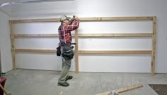 a man is working on the wall in an unfinished room