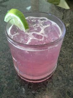 a pink drink with a lime wedge in it