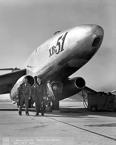 two men are standing next to an airplane