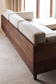 a couch sitting on top of a wooden floor next to a window