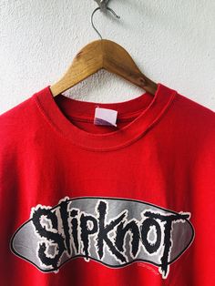 a red shirt with the word slipknot on it hanging from a hanger