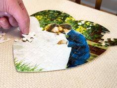 a heart shaped puzzle with a couple kissing on it and missing the piece to be put together