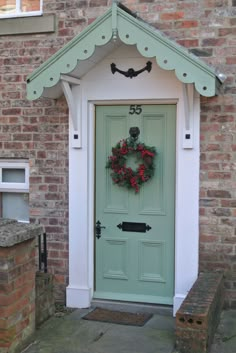 a green front door with a wreath on it