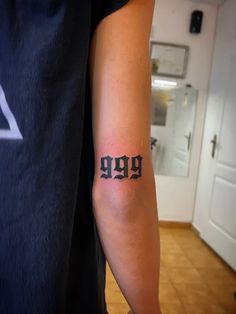 a man with a tattoo on his arm that says 999 in black ink,