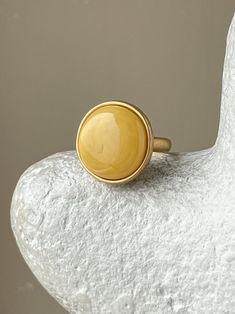 This Large ring with aged amber is skillfully constructed from gold plated sterling silver and showcases a magnificent amber stone. Amber has been valued for generations due to its semi-precious properties, such as its capacity for promoting serenity. Boasting a long-lasting gold plated finish, this ring effortlessly enhances any look. Cheap Gold Brass Rings, Gimel Ring, Madewell Ring, Astoria Ny, Baltic Amber Jewelry, Chunky Ring, Amber Earrings, Amber Ring, Recycled Jewelry