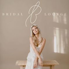 a woman sitting on top of a wooden bench wearing a white dress and tiara