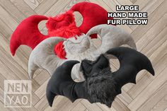 three stuffed animals sitting next to each other on top of a wooden floor with the caption, large hand made fur pillow