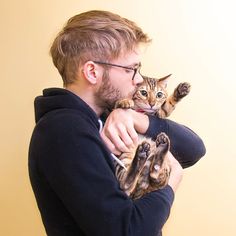 a man holding a cat in his arms