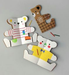 some paper cut out animals are sitting on a table with crayons and pencils