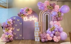 balloons and flowers decorate the entrance to a baby's first birthday party