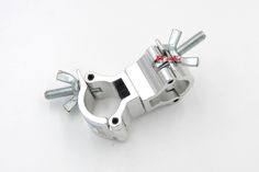 an aluminum clamper with screws and nuts on it's side, sitting on a white surface