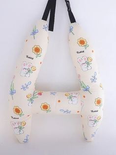 the neck pillow is shaped like an animal with flowers on it and has black straps