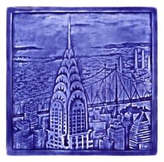 a blue tile with a view of the city and bridge in front of it, on a white background