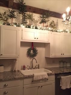 a kitchen with white cabinets and christmas decorations