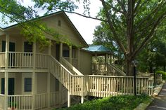 a couple of houses sitting next to each other on the side of a tree lined street