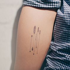 a woman's arm with arrows and stars on the back of her left arm