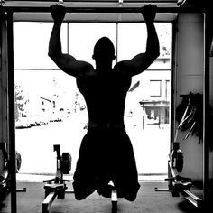 a man is hanging upside down in the gym