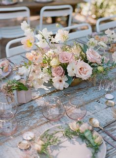 the table is set with flowers and wine glasses