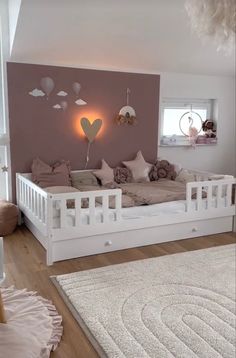 a white day bed sitting in a living room next to a wall with balloons on it