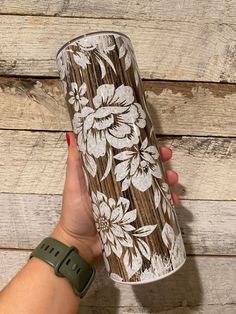 a hand holding a coffee cup on top of a wooden table