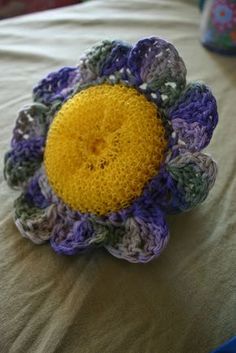 a crocheted flower sitting on top of a bed