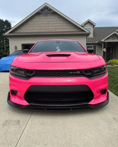 a pink car parked in front of a house