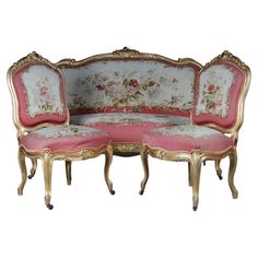 an ornately decorated couch and footstool with pink velvet upholstered cushions