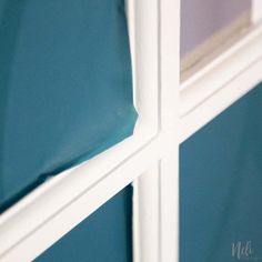 the corner of a window with blue walls and white trim on it's sides