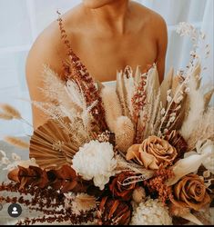 a woman holding a bouquet of dried flowers