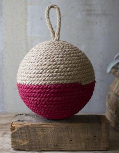 a red and white ball sitting on top of a wooden block