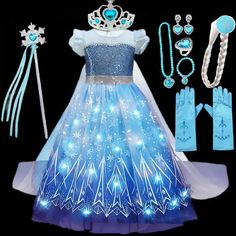 a dress and accessories are displayed on a black background, including gloves, tiara, necklaces, bracelets, and earrings