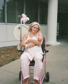 a woman sitting in a wheel chair holding a baby