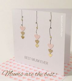 a card with three hearts hanging from it's sides and the words best mum ever