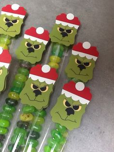 green gummy bears with santa hats on their heads and eyes are lined up in plastic bags