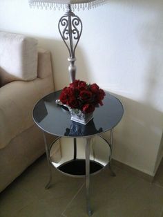 a glass table with flowers on it in front of a couch