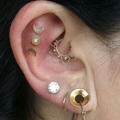 an ear with three different types of piercings on it