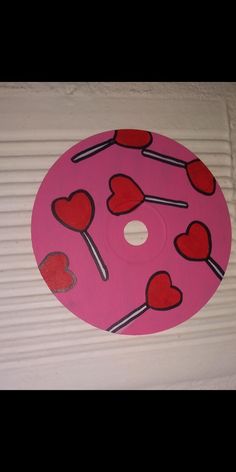 a pink disk with hearts and lollipops on it