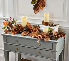 a table with candles and leaves on it