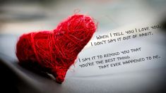 a red yarn heart sitting on top of a table