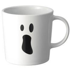 a white coffee cup with a black face drawn on it