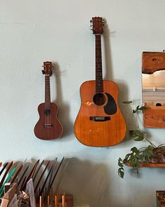 three guitars are hanging on the wall