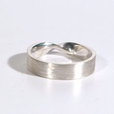 Who doesn't love a simple mobius strip, its a great simple change from a plain band.  The one pictured here is made of solid recycled sterling silver, the first three images show a 5mm wide by 1.5mm thick mobius ring.  I can make this ring in wider widths.  Please see the fourth image to get an idea of how the ring design translates.  8mm and 10 mm wide will be 2mm thick instead of 1.5mm.I love the look of a brushed mobius ring with a polished edge but I am more than happy to do an all polished Modern Twisted Jewelry For Anniversary, Minimalist Twisted Jewelry For Anniversary, Minimalist Curved Wedding Jewelry, Classic Twisted Silver Jewelry, Classic Silver Twisted Jewelry, Modern Twisted Jewelry With Polished Finish, Twisted Modern Jewelry, Modern Twist Curved Ring With Polished Finish, Modern Twist Curved Rings With Polished Finish