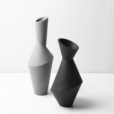 two black and white vases sitting next to each other