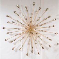 a metal wall sculpture with lots of spoons hanging from it's center point