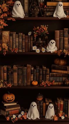 a book shelf filled with lots of books covered in fake ghost heads and pumpkins