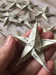 someone is holding a paper origami star with music notes on it and measuring tape