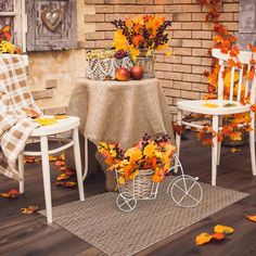 a table with two chairs and a basket full of autumn leaves