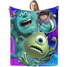 a woman holding up a blanket with monsters on it